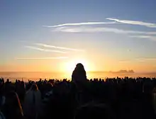 The sun is directly behind the Heel Stone of Stonehenge, at sunrise on the summer solstice