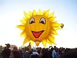 A "smiling sun" hot air balloon behind the sun during the Philippine International Hot Air Balloon Fiesta in Pampanga, Philippines