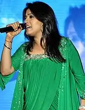 Sunidhi Chauhan performing on stage wearing a green dress