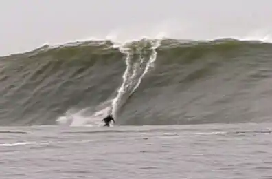 Surfer riding wave on the vicinity of the island