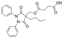 Two-dimensional monochrome diagram showing the structure of the molecule of Suxibuzone, uing the hexagonal style to depict a chemical compound.