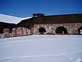 The inner yard of the fortress. To the left is the ruins of the western casemate and to the right is the restored northern casemate.