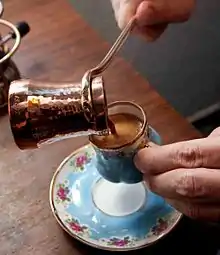 Turkish coffee being poured into a small cup