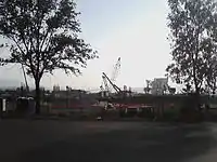 Picture of a construction site, featuring two cranes in the background.