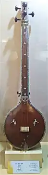 Musical instrument Tamboori on display in a museum behind a glass pane