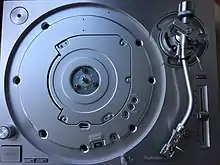 A Technics SL-1200G with the platter removed reveals the top of the newly designed coreless direct drive motor assembly. The platter has no magnet ring on the backside, but is directly bolted onto the motor assembly instead using three flathead bolts.
