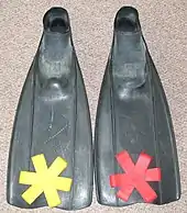 Underwater hockey fins with yellow and red pairs of fin grips.