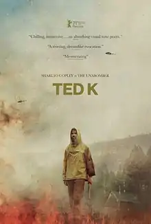 In this poster, Ted Kaczynski holds a firearm in his hand while a helicopter flies overhead.