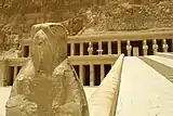 Statue of a falcon (foreground) and stone ramp (background)