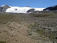 A lobe of glacial ice at the top of a rocky slope