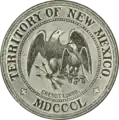 Greyscale drawing of a seal shows 'Territory of New Mexico', 'MDCCCL', and 'crescit eundo' in rings around the edge (separated by crosses patoncé); in the center an American heraldic eagle holding three arrows protects a smaller Mexican heraldic eagle holding a snake and sitting on a nopal.