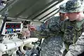 Texas and Czech soldiers examine the levels of water and decontaminate fluids in the tanks of an ACHR-90 large decontamination vehicle.