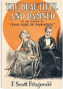 Cover of Fitzgerald's 1922 novel, The Beautiful and Damned, by illustrator W. E. Hill. The cover appears to be a pencil sketch and depicts a young couple who resemble F. Scott Fitzgerald and his wife Zelda. The couple is reclining on a divan in the foreground with a large golden circle in the background. The young man is in a dark suit with a bowtie and white shirt. His arms are folded as if unhappy. The young woman is braless and has her legs crossed. Her hair is bobbed and she is wearing high heels.