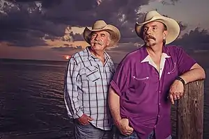 The Bellamy Brothers standing before a purple-tinged sunset