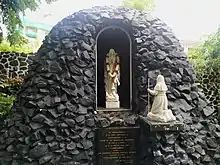 The Church Grotto houses statues of Our Lady of Lourdes and St Bernadette. It was built in 1954, in commemoration of the first centenary of the declaration of the Dogma of the Immaculate Conception of the Blessed Virgin Mary; it has undergone several structural modifications since.