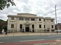 An imposing stone building with pilasters and pediment, bearing the words "Wetherspoons" and "Free House" and, above the door, "The Golden Beam"