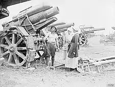 Two nurses checking a 21 cm Mörser 16 heavy howitzer at a dump of German artillery captured by the British Fourth Army.