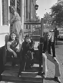 A black-and-white photo of the band on a stairwell