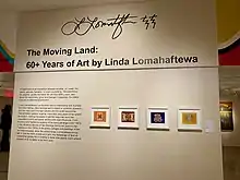 Entrance to the exhibition, showing the title, curatorial statement, and four 2D artworks.