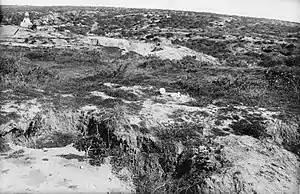 The terrain around Baby 700 as viewed from The Nek, taken after the war. There is a Turkish memorial in the distance, and sun bleached human remains in the foreground