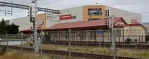 The old Henderson railway station with WestCity Waitakere in the background