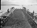 At Scapa Flow, a Royal Navy net laying vessel prepares to lay an anti-submarine net, which is 900 feet (275 metres) long, weighs over 40 Imperial tons (41 tonnes) and could be laid in 4 minutes.
