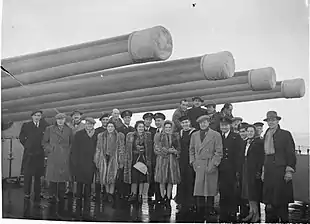 A group of civilian performers on the deck of a warship