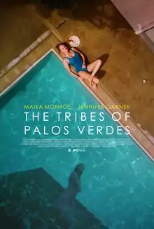 An overhead view of a woman in a blue bathing suit lying at the edge of a swimming pool. The water of the pool shows the shadowy reflection of another woman.