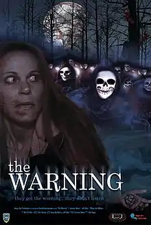 On the poster is the face of a woman and many white masked faces with black eyes, in a charred forest in the background and the text at the bottom: "They got the warning...they didn't listen.". In the sky is a large moon with a red pentagram on it. A hand carved with a pentagram is on the bottom of the poster. The title "The Warning", film credits and the release date appear at the bottom