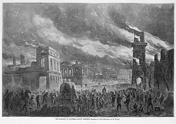 A sketch of a city landscape in ruins, with a crowd of people gathered at the base of the buildings