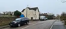 White painted detached house in urban setting