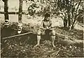 A Dayak man from Sabah, Malaysia tying a spearhead on a sumpitan (c. 1912)