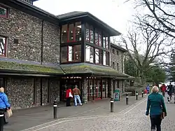 Modern stone-faced theatre with a lake in the background