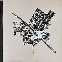An excerpt of a black-and-white aerial photograph of several buildings surrounding a road labeled "Massachusetts".