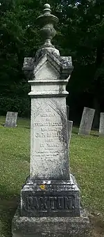 Photo of tilted white pillar engraved with Paxton's information