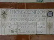 A tablet formed of five tiles of varying sizes, bordered by yellow and blue flowers in an art nouveau style