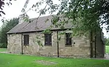 Image of old church building with a tree obscuring the right end