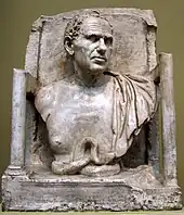 Photograph of a square sculpture showing the head and shoulders of a man, wearing a toga.