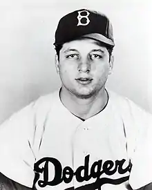 A man in a light baseball uniform and dark cap