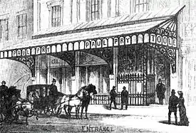 Street view of front of Victorian theatre of modest proportions, with glass and iron canopy across its width
