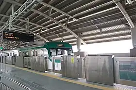 Top: Outside view of Uttara North metro stationBottom: Train entering at the platform of Agargaon metro station