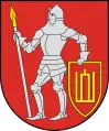 A coat of arms depicting a man in full body armour holding a white spear in his right hand and a red-and-yellow shield in his left hand