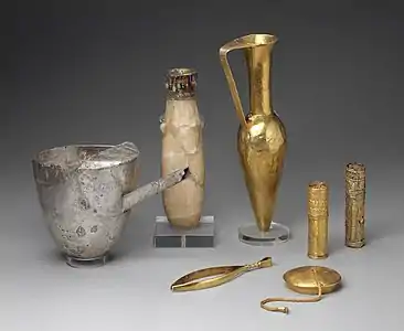 Artifacts including large metal tweezers, decorated and inscribed vessels, gold sheaths, and a ewer marked for King Aspelta found in Nuri pyramid 8. Museum of Fine Arts, Boston.