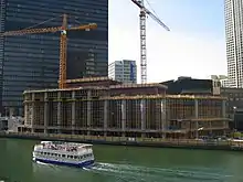the first few floors of construction of a building from across a river