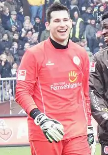 Tschauner smiling while standing on-field