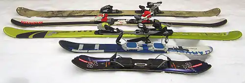 Twintip skis (back to front: backcountry ski, park ski with wood core, park ski with foam core, skiboards