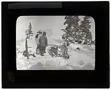 Two men with a sled on a winter trail