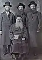 Seated: Grand Rabbi Naftali Aryeh Spiegel of Ostrov-Kalushin. Back (l-r) Rabbis Elchonon Yochanan, Pinchas Eliyahu, and Moshe Menachem Spiegel.