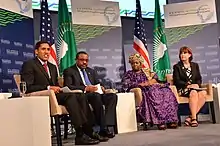 Four political leaders sit on a stage facing an audience. They are answering questions at a food security and climate change session.