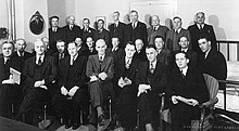 A large group of white men in suits posing for a picture